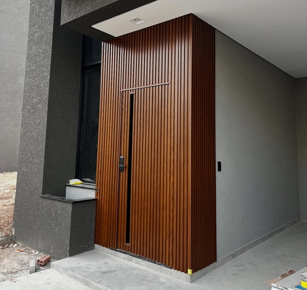 Fachada com porta pivotante e painel ripado em madeira — BR Portas